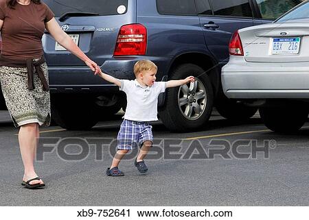 A toddler walking with his mother View Large Photo Image Stock Image - A toddler walking with his mother. Fotosearch