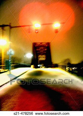 Stock Photograph - A train trestle is captured at night during the winter with fresh fallen snow. Ghostly and mysterious.. Fotosearch