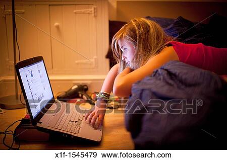 a twelve thirteen year old teenage girl in her bedroom reading Facebook page on laptop computer UK View Large Photo Image Stock Photo - a twelve thirteen year old teenage girl in her bedroom reading Facebook page on laptop computer UK. Fotosearch