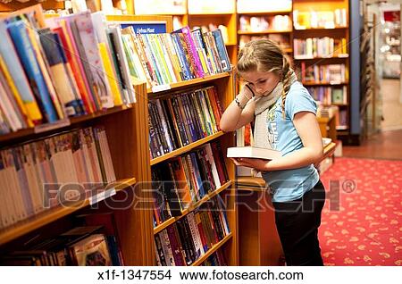 A twelve year old teenage girl reading in a bookshop, UK View Large Photo Image Picture - A twelve year old teenage girl reading in a bookshop, UK. Fotosearch