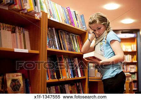 A twelve year old teenage girl reading in a bookshop, UK View Large Photo Image Stock Photography - A twelve year old teenage girl reading in a bookshop, UK. Fotosearch