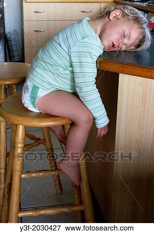 A two-year-old boy, sits up, fast asleep waiting for his supper... View Large Photo Image Stock Photo - A two-year-old boy, sits up, fast asleep waiting for his supper.... Fotosearch