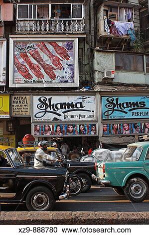 Stock Image - A view of a street in Mumbai, near Bazar Chor, showing traffic and advertisments for? henna tatoo? and perfumers. Fotosearch