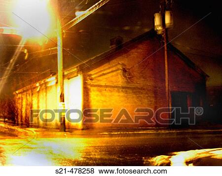 A warehouse on a desolute street corner is captured at night with a slight blur creating a mysterious, painterly effect. View Large Photo Image Stock Photo - A warehouse on a desolute street corner is captured at night with a slight blur creating a mysterious, painterly effect.. Fotosearch