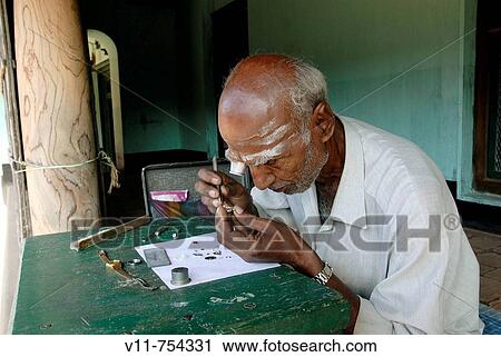 A watch repairer (old man) sitting in front of an agraharam house (brahmin house) in Konerirajapuram near Kumbakonam, Tamil Nadu, South India, India. View Large Photo Image Stock Image - A watch repairer (old man) sitting in front of an agraharam house (brahmin house) in Konerirajapuram near Kumbakonam, Tamil Nadu, South India, India.. Fotosearch
