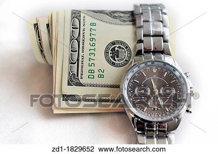 A watch shows the time over American Dollars Bills View Large Photo Image Stock Image - A watch shows the time over American Dollars Bills. Fotosearch
