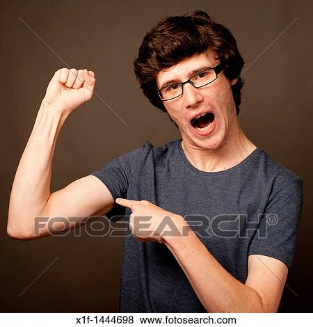 a weak feeble geek nerd youn man with thin arms wearing glasses flexing his muscles View Large Photo Image Stock Photo - a weak feeble geek nerd youn man with thin arms wearing glasses flexing his muscles. Fotosearch