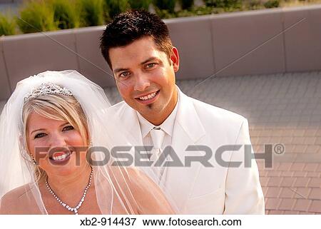 A wedding couple celebrate their wedding in a local park. View Large Photo Image Stock Photo - A wedding couple celebrate their wedding in a local park.. Fotosearch