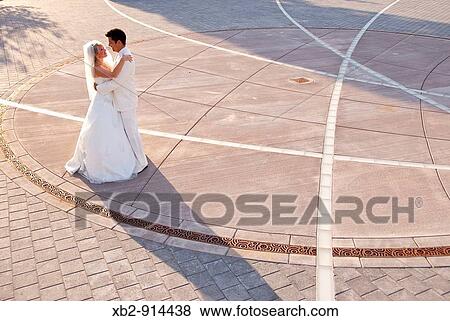 A wedding couple celebrate their wedding in a local park. View Large Photo Image Stock Photo - A wedding couple celebrate their wedding in a local park.. Fotosearch