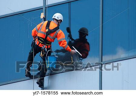 Stock Photography - A window cleaner at work on an office building in Birmingham, UK. Fotosearch
