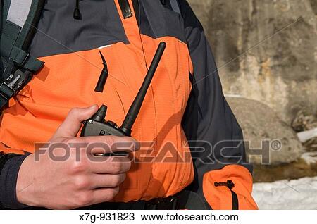 Stock Image - A winter hiker with emergency radio. Fotosearch