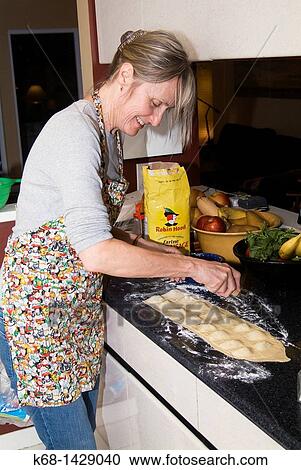 a woman, 56, prepares fresh pasta in her kitchen View Large Photo Image Stock Image - a woman, 56, prepares fresh pasta in her kitchen. Fotosearch