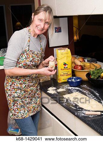 Stock Image - a woman, 56, prepares fresh pasta in her kitchen. Fotosearch