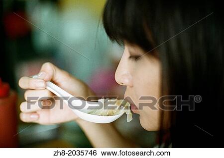 A woman about to eat a won ton soup dumpling in Kaohsiung, Taiwan. View Large Photo Image Stock Photograph - A woman about to eat a won ton soup dumpling in Kaohsiung, Taiwan.. Fotosearch