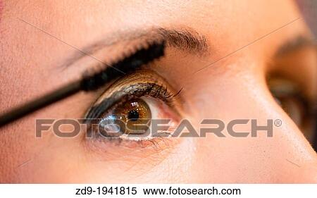 Stock Photography - A woman applies mascara.. Fotosearch