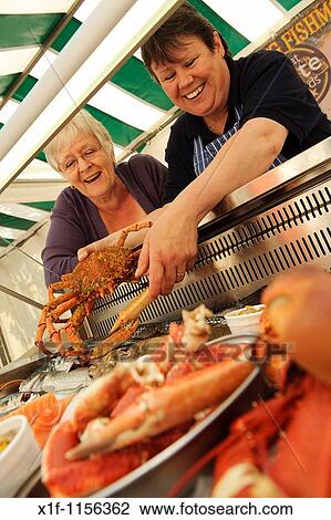 A woman buying fresh local seafood on Aberystwyth farmers market, Wales UK View Large Photo Image Stock Image - A woman buying fresh local seafood on Aberystwyth farmers market, Wales UK. Fotosearch