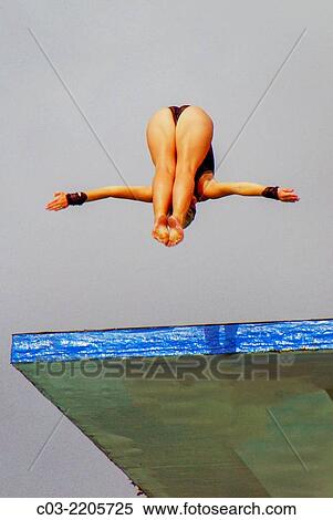 A woman competition diver jumps from a high diving board in Mission Viejo, CA. Note wrist water impact guards. View Large Photo Image Stock Photography - A woman competition diver jumps from a high diving board in Mission Viejo, CA. Note wrist water impact guards.. Fotosearch