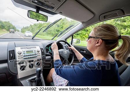 A woman driving shown from the interior of the car in the Uk. View Large Photo Image Stock Image - A woman driving shown from the interior of the car in the Uk.. Fotosearch