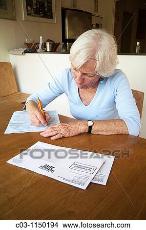 Picture - A woman fills out her 2010 U S Census form at home in California Administered every ten years, the census is an important tool of efficient government. Fotosearch