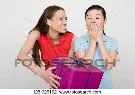 a woman giving a gift to a young woman View Large Photo Image Stock Image - a woman giving a gift to a young woman. Fotosearch