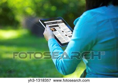 A woman hand holding an iPad while reading online news View Large Photo Image Stock Photo - A woman hand holding an iPad while reading online news. Fotosearch