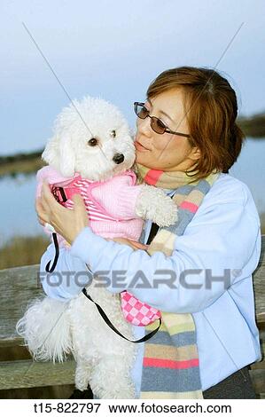 Stock Photo - a woman holding and looking at her dog. Fotosearch