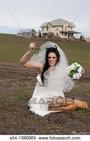 A woman in a bridal gown, crying and sitting in a desolate field, tearing apart her flowers. View Large Photo Image Stock Photography - A woman in a bridal gown, crying and sitting in a desolate field, tearing apart her flowers.. Fotosearch