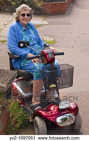 A woman in her 70's on a mobility scooter in the Uk View Large Photo Image Stock Image - A woman in her 70's on a mobility scooter in the Uk. Fotosearch