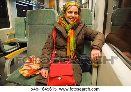 Stock Photography - A woman in her late 20s travelling on narrow gauge train between Bavaria in Germany and Czech Republic Europe. Fotosearch