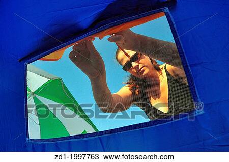 A woman is opening the window of a tent during camping on a camp ground. View Large Photo Image Stock Image - A woman is opening the window of a tent during camping on a camp ground.. Fotosearch
