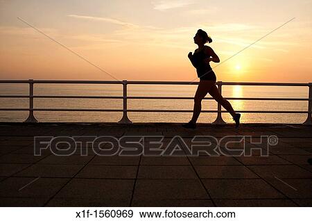 a woman jogger at dusk on a warm september evening aberystwyth promenade wales uk View Large Photo Image Stock Photo - a woman jogger at dusk on a warm september evening aberystwyth promenade wales uk. Fotosearch