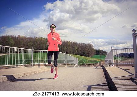 a woman jogging through the rural landscape near Coburg, Germany. View Large Photo Image Stock Image - a woman jogging through the rural landscape near Coburg, Germany.. Fotosearch