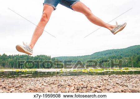 A woman jumping beside a lake in Bowen Island, British Columbia, Canada. View Large Photo Image Stock Photo - A woman jumping beside a lake in Bowen Island, British Columbia, Canada.. Fotosearch