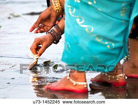 A woman lighting a candle during a puja ceremony in India. View Large Photo Image Stock Photography - A woman lighting a candle during a puja ceremony in India.. Fotosearch
