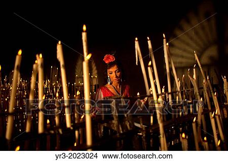 A woman lights a candle in the Votive Room of the shrine of the Virgin of Rocio, in Almonte, Donana National Park, Huelva province, Andalusia, Spain View Large Photo Image Picture - A woman lights a candle in the Votive Room of the shrine of the Virgin of Rocio, in Almonte, Donana National Park, Huelva province, Andalusia, Spain. Fotosearch