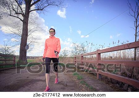 a woman nordic walking through the rural landscape near Coburg, Germany. View Large Photo Image Stock Image - a woman nordic walking through the rural landscape near Coburg, Germany.. Fotosearch
