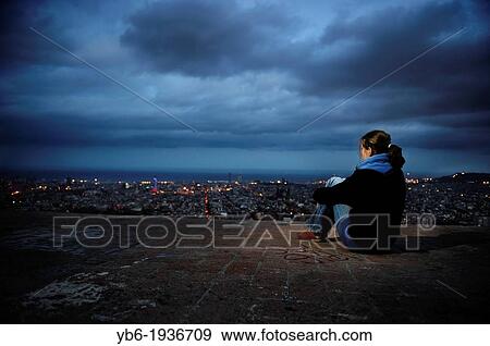 A woman observes the illuminated Barcelona Skyline by night, Spain. View Large Photo Image Stock Photo - A woman observes the illuminated Barcelona Skyline by night, Spain.. Fotosearch