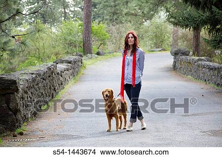 Picture - A woman outdoors with her Golden Retriever. Fotosearch