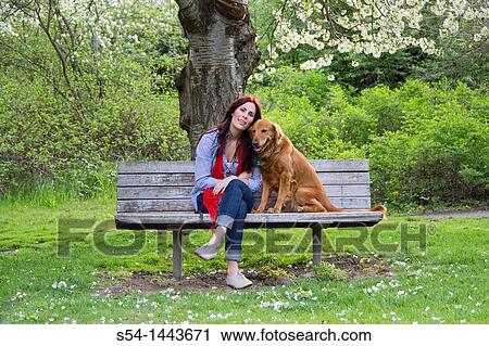 Stock Image - A woman outdoors with her Golden Retriever. Fotosearch