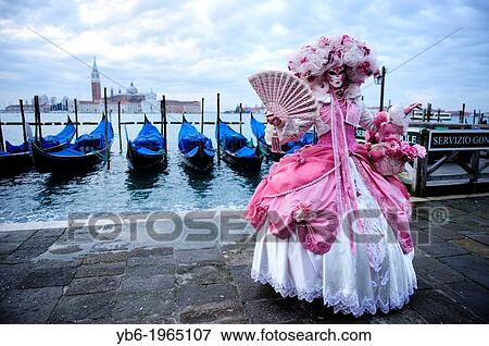 Stock Photo - A woman posing with a full Carnival costume at the Venice waterfront, Italy.. Fotosearch