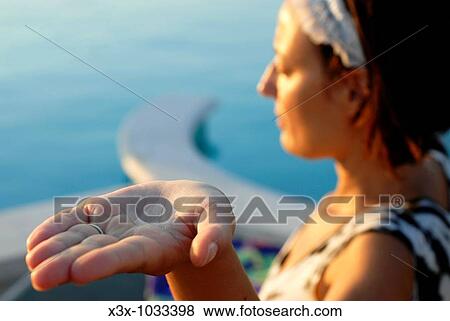 Stock Photo - A woman practicing a yoga position with open palm hand. Fotosearch