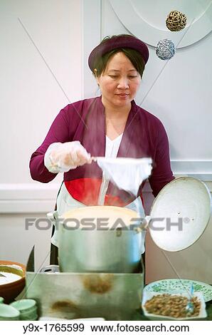 Stock Photo - A woman preparing food for a buffet at the Metropole hotel in Vietnam. Fotosearch