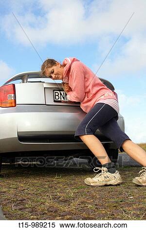 a woman pushing a broken down car View Large Photo Image Stock Photography - a woman pushing a broken down car. Fotosearch