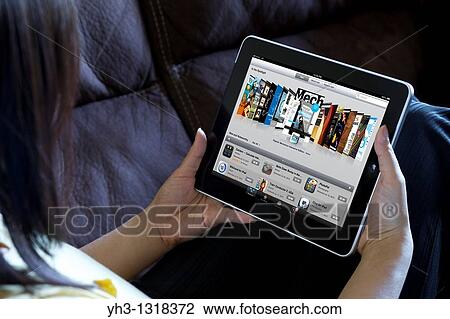 A woman relaxing while browsing Apple iPad applications store View Large Photo Image Stock Image - A woman relaxing while browsing Apple iPad applications store. Fotosearch