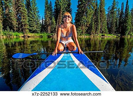 A woman riding the Stand Up Paddle Board on the North Fork of the Payette River near Payette Lake and the city of McCall in the Salmon River Mountains of central Idaho. View Large Photo Image Stock Image - A woman riding the Stand Up Paddle Board on the North Fork of the Payette River near Payette Lake and the city of McCall in the Salmon River Mountains of central Idaho.. Fotosearch