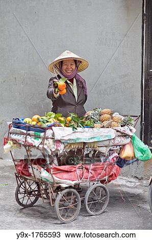 A woman selling fruits from a cart in a back alley of Vietnam View Large Photo Image Stock Image - A woman selling fruits from a cart in a back alley of Vietnam. Fotosearch