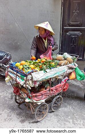 A woman selling fruits from a cart in a back alley of Vietnam View Large Photo Image Stock Photo - A woman selling fruits from a cart in a back alley of Vietnam. Fotosearch