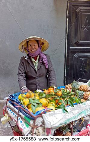 A woman selling fruits from a cart in a back alley of Vietnam View Large Photo Image Stock Photo - A woman selling fruits from a cart in a back alley of Vietnam. Fotosearch
