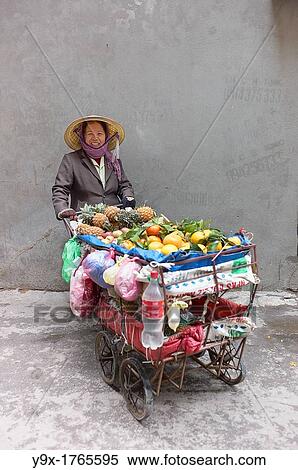 A woman selling fruits from a cart in a back alley of Vietnam View Large Photo Image Stock Photography - A woman selling fruits from a cart in a back alley of Vietnam. Fotosearch