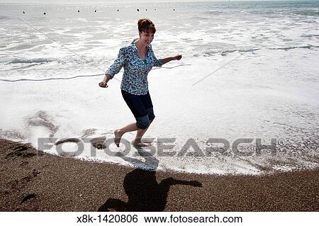 A woman splashes about in the Pacfic Ocean at Rodeo Cove near San Francsico, CA View Large Photo Image Stock Photograph - A woman splashes about in the Pacfic Ocean at Rodeo Cove near San Francsico, CA. Fotosearch